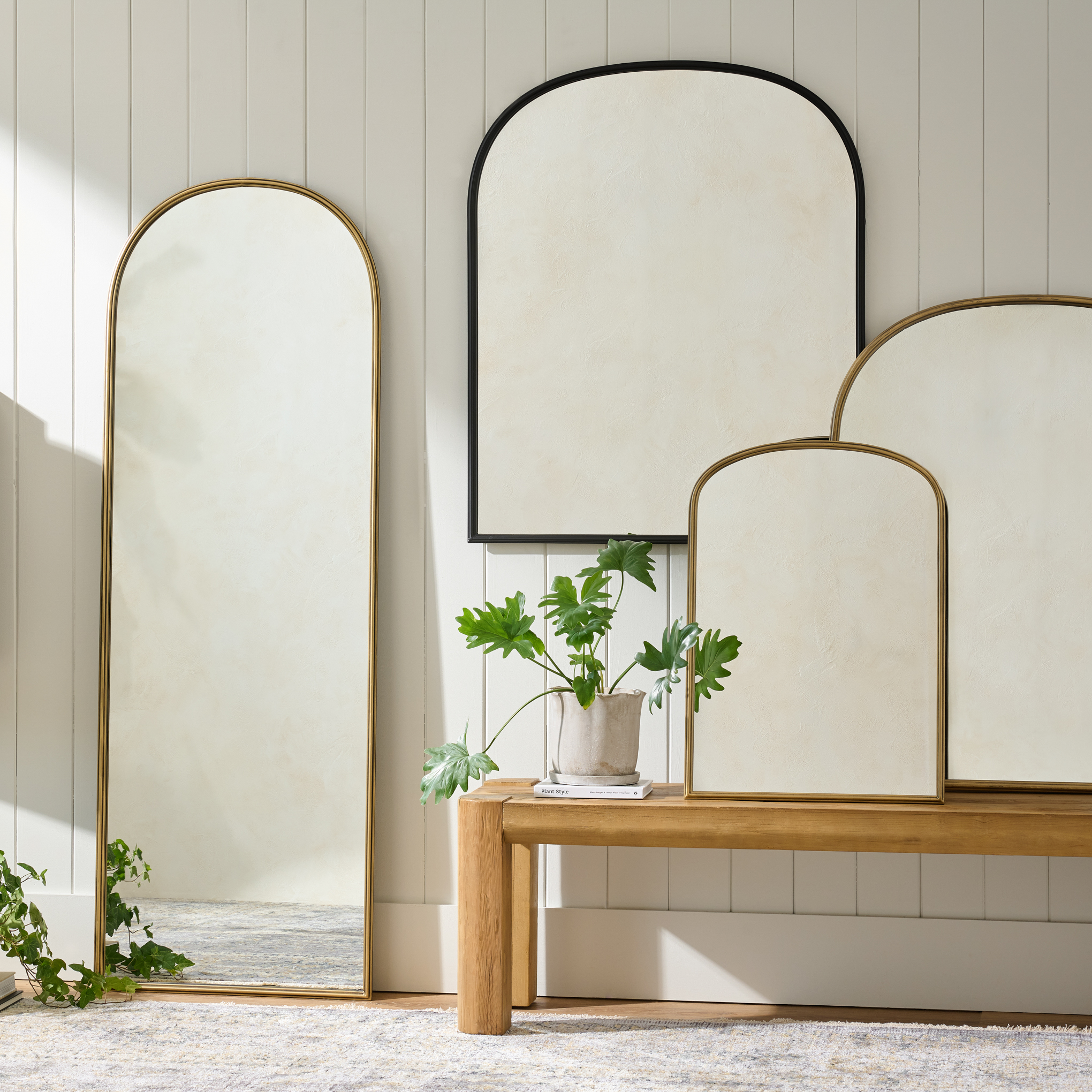 archer wall mirrors sit in a room against a shiplap wall above a bench