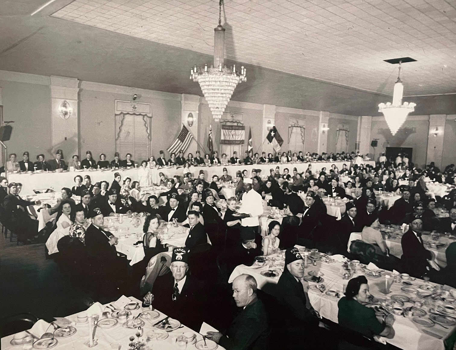 People dining in an old ballroom. 