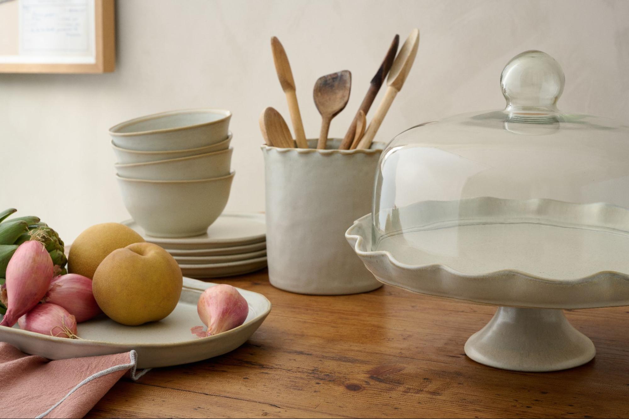 Grey-toned kitchen pieces from Magnolia sit on a wooden tabletop.