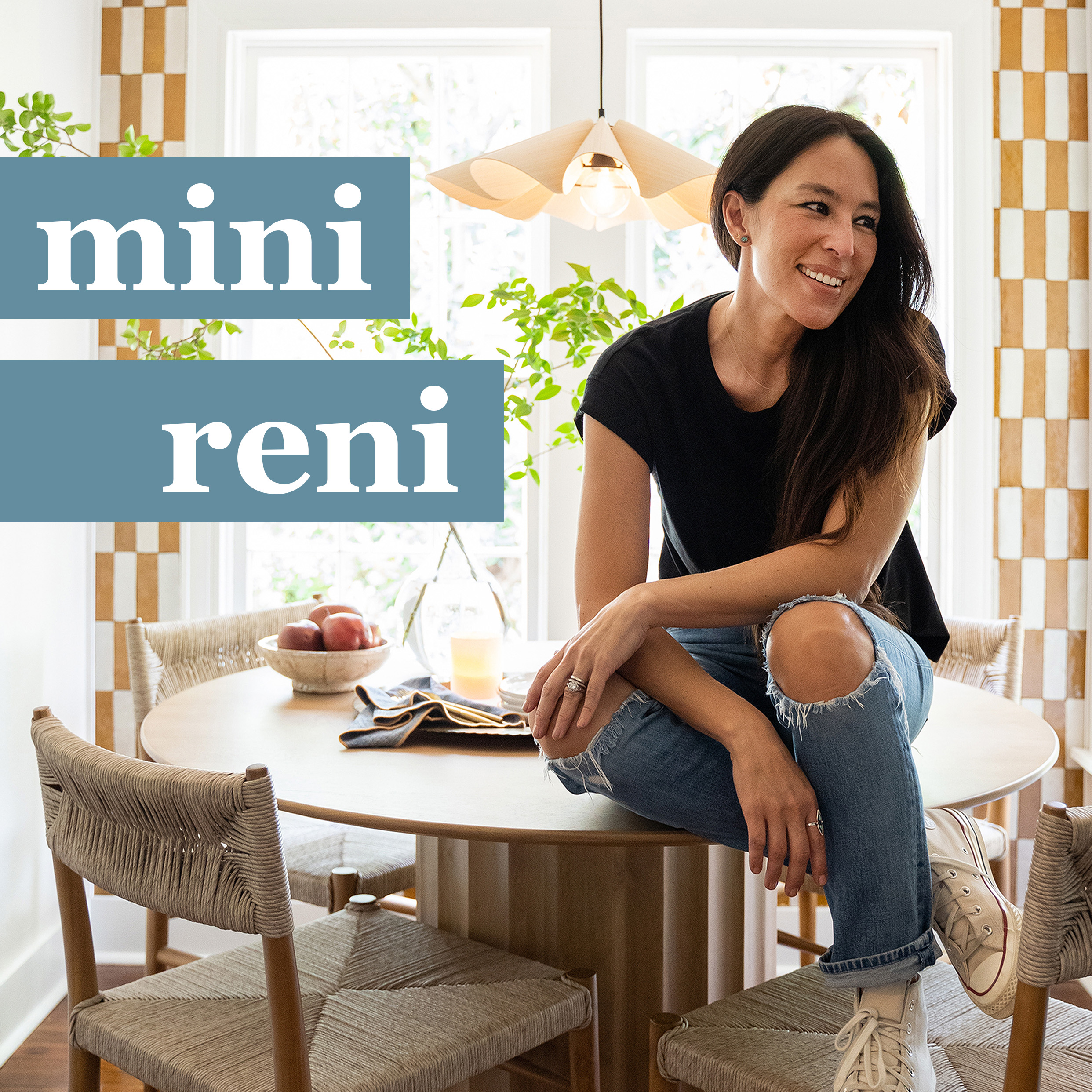 mini reni. joanna gaines sits on a table in a breakfast nook. 